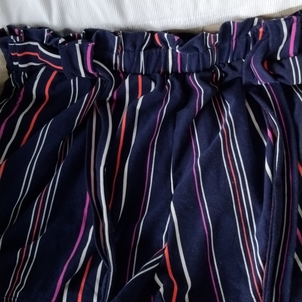 Blue short with white purple and neon orange stripes and a little white spaghett